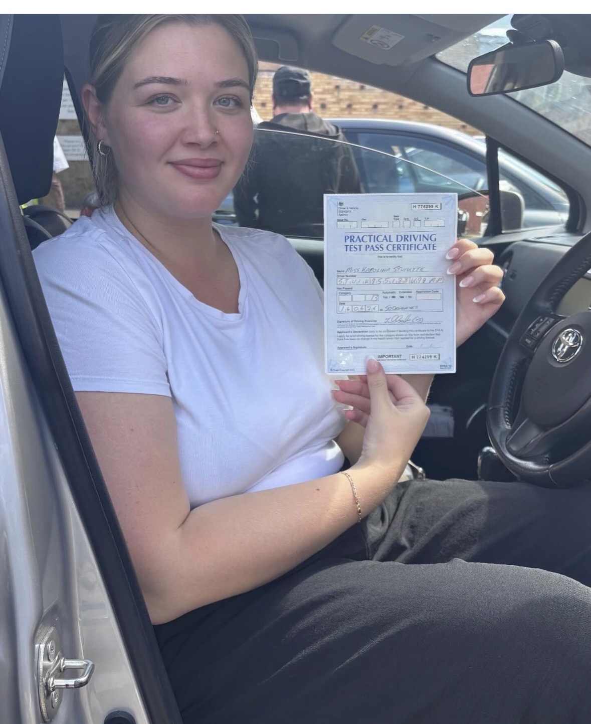 Happy learner with their practical driving test pass certificate