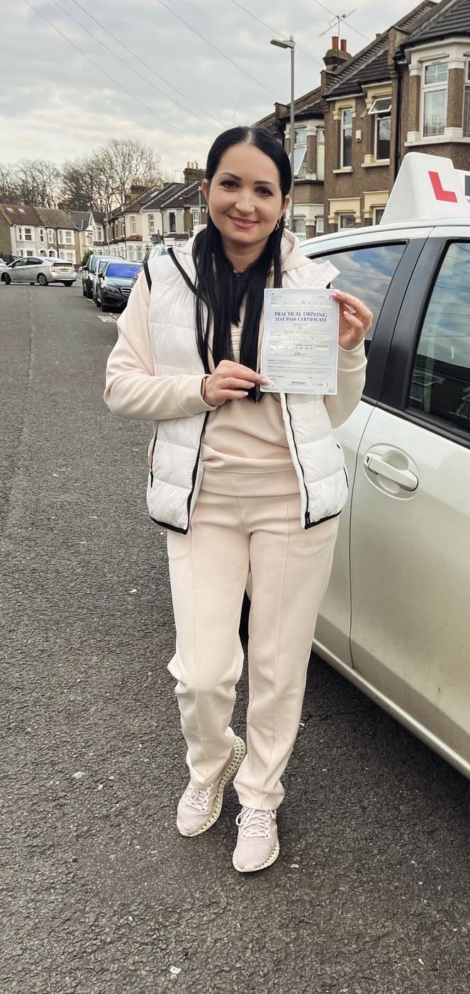 Newly qualified driver beside the car with pass certificate